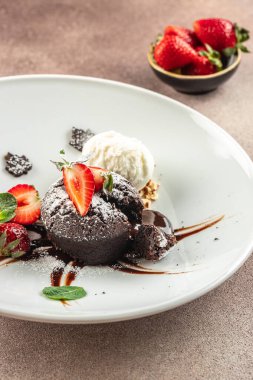 Taze çilekli çikolatalı lav keki, dondurma topu ve nane, yemek tarifi geçmişi. Kapat.,