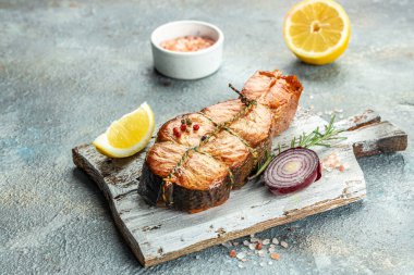 Bitkilerle pişirilmiş somon bifteği, limon, zeytinyağı, sağlıklı yemek için ızgara taze balık, restoran menüsü, diyet, yemek tarifi üst görünüm.,