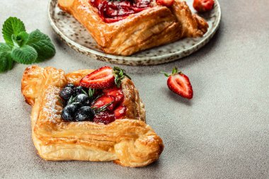 Hafif arka planda böğürtlenli lezzetli puf börekleri, yemek tarifi geçmişi. Kapat.,