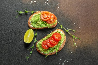 Kahvaltıda ya da öğle yemeğinde sağlıklı avokado tostları ve çavdar ekmeği. Vejetaryen yemeği. Vejetaryen menüsü. afiş, menü, metin için tarif yeri, üst görünüm,