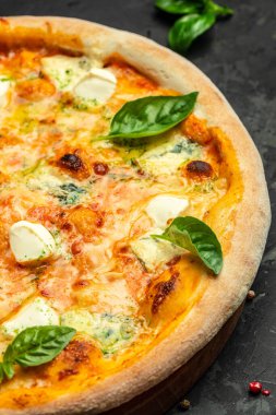 Koyu arkaplanda dört peynirli pizza, dikey görüntü. Üst Manzara. metin için yer.