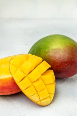 Kırmızı mango meyvelerinin yarısı beyaz arka planda. Mango kırpma yolu. dikey görüntü. Üst Manzara. metin için yer.