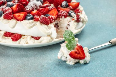 Taze ahududu, yaban mersini ve çilekli pavlova pastası, yemek tarifi geçmişi. Kapat.,