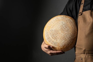 cheesemaker mele hands holding wheel hard cheese,