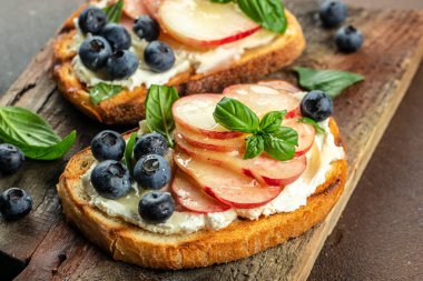 Tatlı tost, ricotta peyniri, bal ve şeftali, ahşap bir tahtanın üzerinde, yemek tarifi geçmişi. Kapat.,