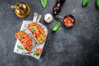 Tahtada domates, sarımsak ve otlarla İtalyan aperatifi, İtalyan bruschetta aperatifleri, yazı için yer, üst görünüm.,