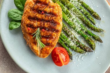 Sebzeli kuşkonmaz ve parmesanlı organik sağlıklı ürünlerle ızgara yapılmış sulu tavuk göğsü. Detoks ve temiz diyet konsepti. metin için yer, üst görünüm,