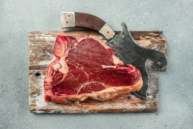 Tahta bir tahtanın üzerinde çiğ biftek. afiş, menü, metin için tarif yeri, üst görünüm.