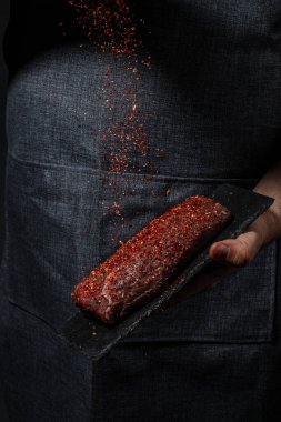 Et pişirmek ve baharat eklemek, arka planda ızgara baharatlı biftek. Restoran menüsü, diyet, yemek kitabı tarifi..