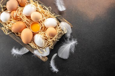 Koyu arkaplanda tahta bir kutuda yumurta ve yumurta sarısı. en üstteki görünüm,