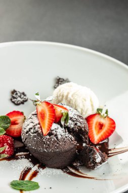 Çilekli çikolatalı lav keki. Sıvı dolgulu geleneksel Fransız çikolatalı keki.,