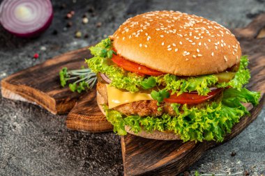 Fast food Burger with beef, tomato, cheese, and lettuce. junk food concept.