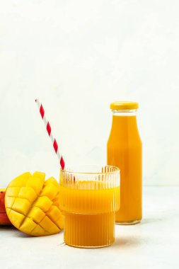 Lezzetli bir mango içeceği ve arka planda taze meyveler. dikey görüntü. Üst Manzara. metin için yer,
