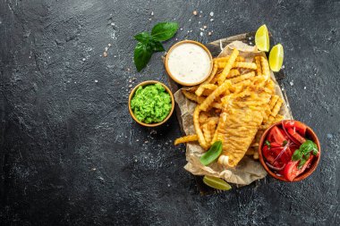 Balık ve patates kızartması geleneksel İngiliz yemeği bezelye püresi, sebze salatası, tartar sosu, pankart, menü, yazı için tarif yeri, üst görünüm,