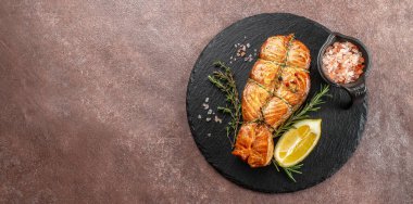 Fırında somon ızgara limon ve hafif arka planda tuz. Uzun afiş biçimi. en üstteki görünüm.