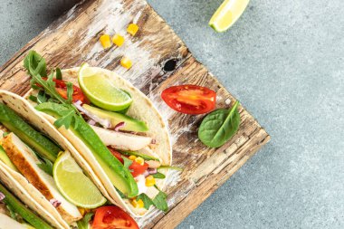 Kızarmış tavuk, avokado, taze domates ve limonlu sağlıklı mısır tortillası. metin için yer, üst görünüm.