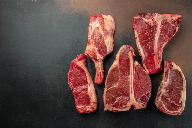 Çiğ Black Angus Prime bifteği T-bone, tomahawk, New York bifteği çeşitleri. Çiğ mermer sığır filetosu bifteği koyun. metin için yer, üst görünüm.