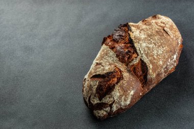 Karanlık bir arka planda taze ev yapımı ekşi ekmek. afiş, menü, metin için tarif yeri, üst görünüm.