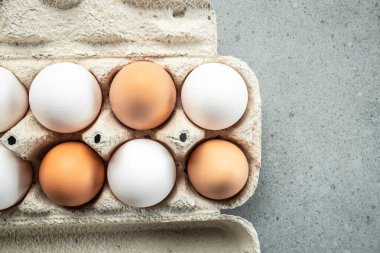 Çiğ kahverengi yumurta ve tavuk tüylü beyaz yumurta, tarım, biyolojik ve eko çiftçilik kavramı, biyolojik gıda ürünleri. metin için yer,