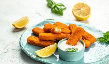 Crumbed fish sticks served with lemon and tartar sauce. Long banner format. top view. clipart