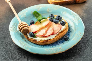 Krem peynir, bal, şeftali ve yabanmersinli aperatif meyve bruschetta. Restoran menüsü, diyet, yemek kitabı tarifi üst görünümü.