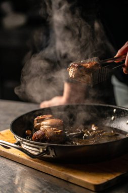 beef tenderloin steak is grilled in a grill pan with steaming. vertical image. top view. place for text.