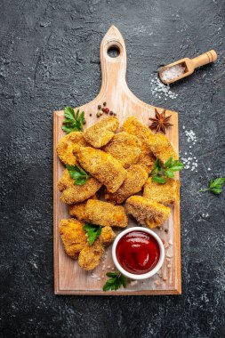 Tahta üzerinde ketçap olan çıtır tavuk nuggetları. dikey görüntü. Üst Manzara. metin için yer,
