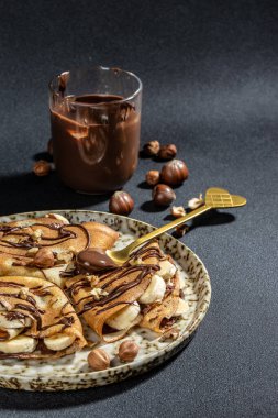 Kahvaltıda ya da tatlıda çikolatalı ve fındıklı ev yapımı ince krepler. metin için yer, üst görünüm.