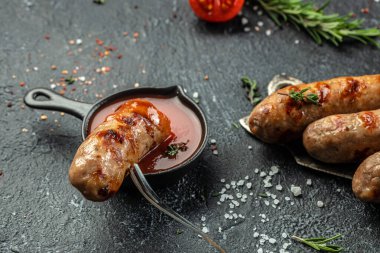 Biberiyeli ızgara sosis ve çatal. Baharatlı et sosisleri, dikey görüntü. metin için yer.