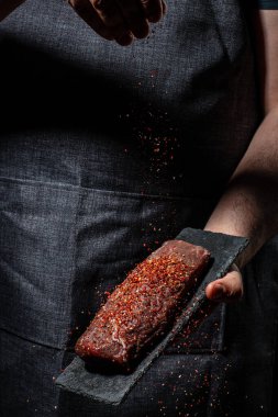 Et pişirmek ve baharat eklemek, arka planda ızgara baharatlı biftek. Restoran menüsü, diyet, yemek kitabı tarifi..