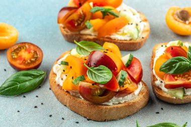 Krem peynirli, şeftalili, domatesli ve yeşil fesleğenli sağlıklı vejetaryen meyve sandviçi. Temiz diyet konsepti. metin için yer, üst görünüm.