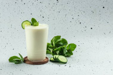 Mavi arka planda salatalıklı ev yapımı yoğurt Ayran, kilo vermek için temiz yemek. metin için yer.