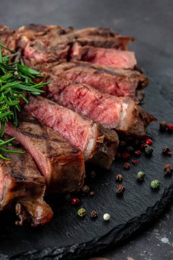 Koyu arkaplanda az pişmiş ızgara biftek. en üstteki görünüm.