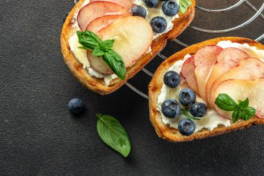 Tatlı tost, ricotta peyniri, bal ve şeftali, ahşap bir tahtanın üzerinde, yemek tarifi geçmişi. Kapat.,