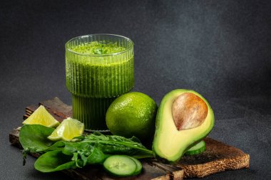 Detoks smoothie, sağlıklı diyet ve beslenme. Koyu arkaplanda yeşil smoothie, kilo vermek için temiz yemek. metin için yer.
