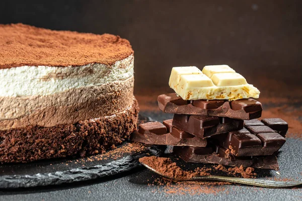 Mousse cake three chocolate on a dark background. Restaurant menu, dieting, cookbook recipe top view,