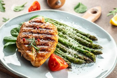 Sebzeli kuşkonmaz ve parmesanlı organik sağlıklı ürünlerle ızgara yapılmış sulu tavuk göğsü. Detoks ve temiz diyet konsepti. metin için yer, üst görünüm,