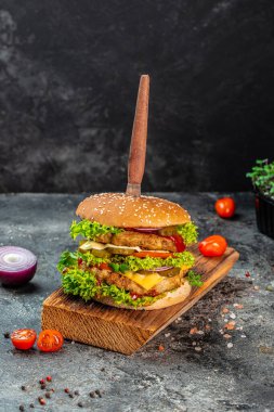 Sığır eti, domates, peynir, pastırma ve marullu ev yapımı leziz ızgara burger. Fast food ve abur cubur kavramı.