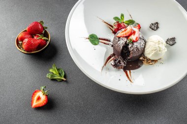 Çilekli çikolatalı lav keki. Sıvı dolgulu geleneksel Fransız çikolatalı keki.,