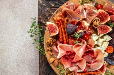 Kurutulmuş jambondan aperatif, incir ve peynirli jambon dilimleri. Akşam yemeği ya da aperatif parti konsepti. metin için yer, üst görünüm.