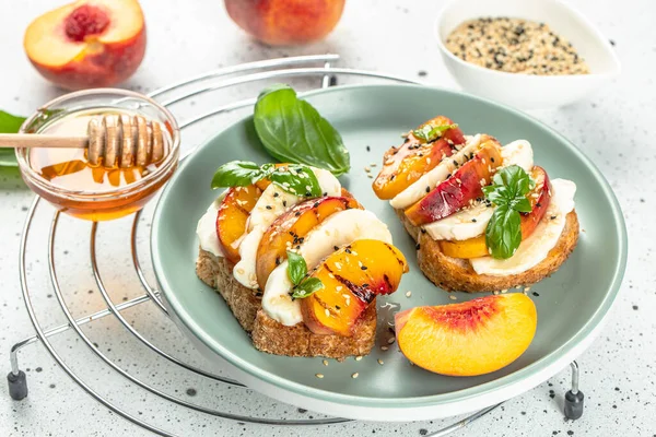 Toast with cream cheese, Grilled peach salad with mozzarella, basil. Delicious breakfast or snack.