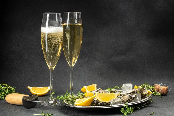 fresh oysters and lemons in bowl near champagne glasses. banner, menu, recipe place for text.