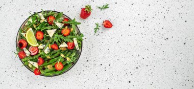 Hafif arka planda kuşkonmaz ve çilek salatası. organik sağlıklı ürünler. Detoks ve temiz diyet konsepti. Uzun afiş biçimi. en üstteki görünüm,