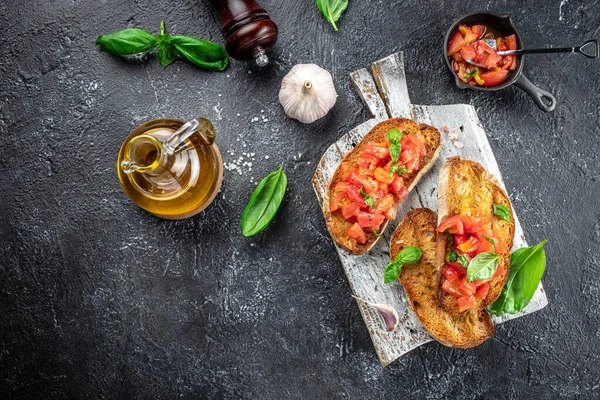 Italian tomato bruschetta with basil, garlic and olive oil on grilled or toasted crusty ciabatta bread, banner, menu, recipe place for text, top view,