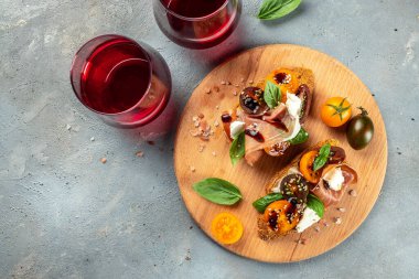 Prosciutto ile bruschetta, kiraz domatesleri fesleğen yapraklı krem peynir, antipasto şarabı. metin için yer, üst görünüm.