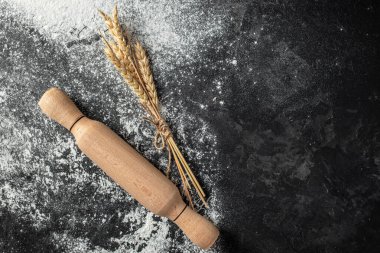 Buğday unu, tahıl ve kulaklar koyu arkaplanda. afiş, menü, metin için tarif yeri, üst görünüm.