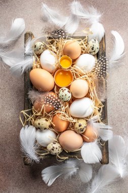 Hafif arka planda tahta bir kutuda yumurta ve yumurta sarısı. en üstteki görünüm,