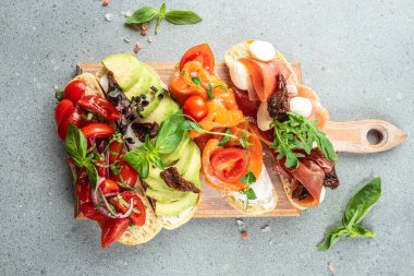 Tahta bir tahtada jambon, somon, domates ve avokado soslu bruschetta seti, pankart, menü, yazı için tarif yeri, üst görünüm.,