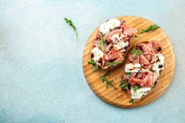 Jamon serrano paleta iberico jambonlu sandviç, ahşap tahtada roka krem peynir, yazı için yer, üst manzara.,