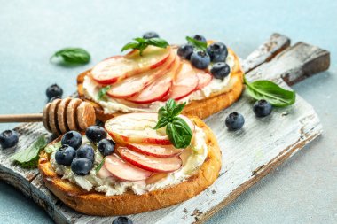 Şeftalili tost, ricotta, ahşap bir tahtanın üzerinde yabanmersini. Yemek tarifi geçmişi. Kapat..